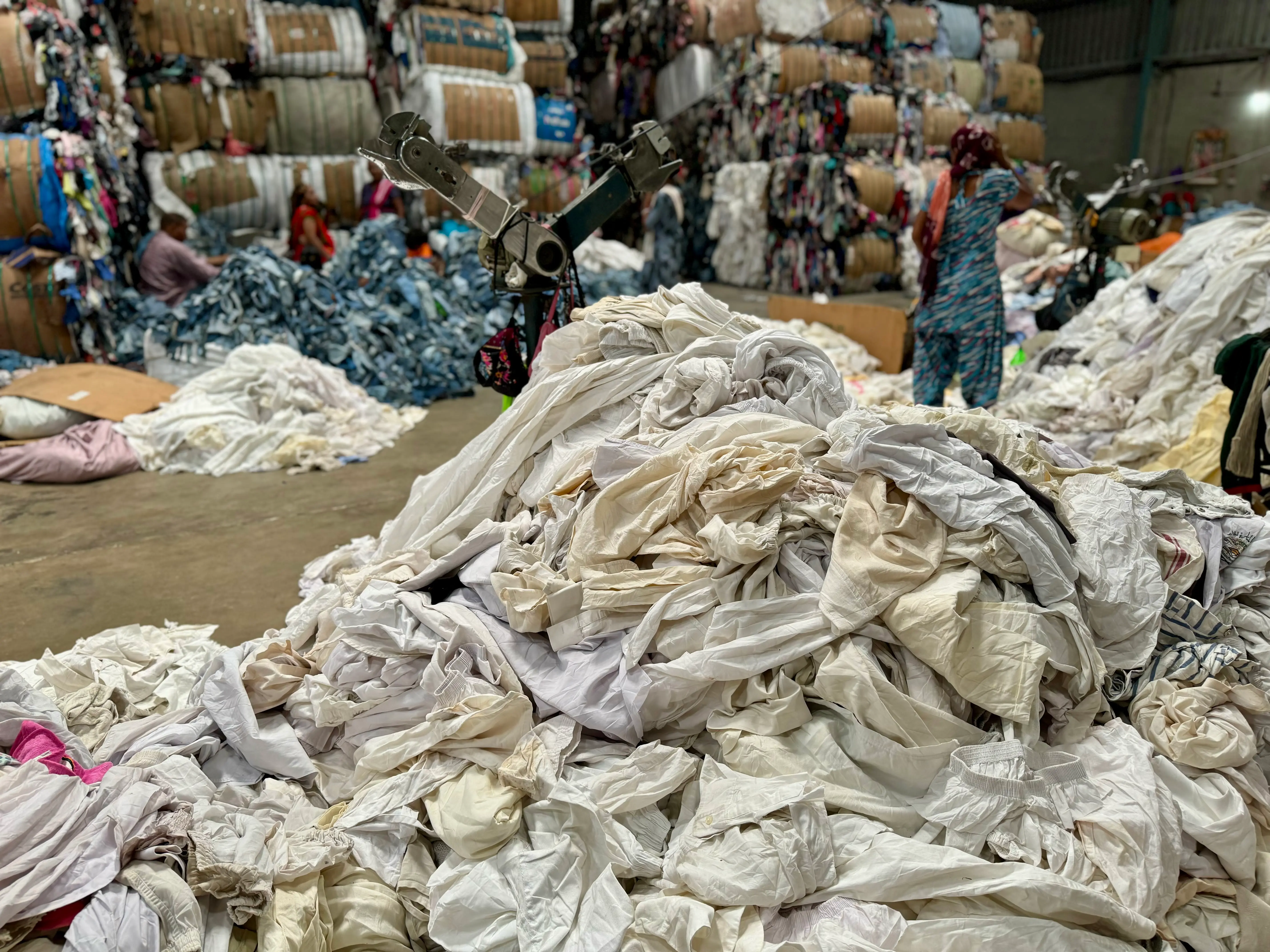 huge pile of white cloth to be cut into white cotton t shirt wiper